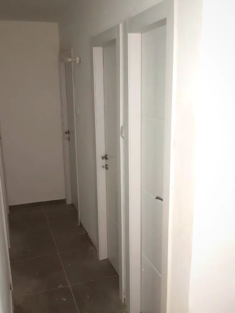 מסדרון עם שלוש דלתות לבנות מותקנות