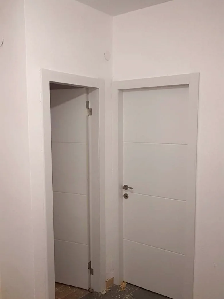שתי דלתות בעיצוב ארבעה פסים בפינת מסדרון